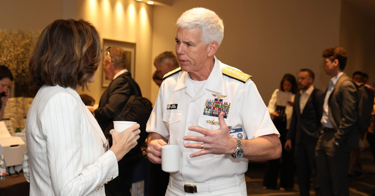 Photo of Navy Vice Adm. Karl Thomas (right) speaking with SAIC's Barbara Supplee on August 26, 2025 at the 2025 Navy Summit.