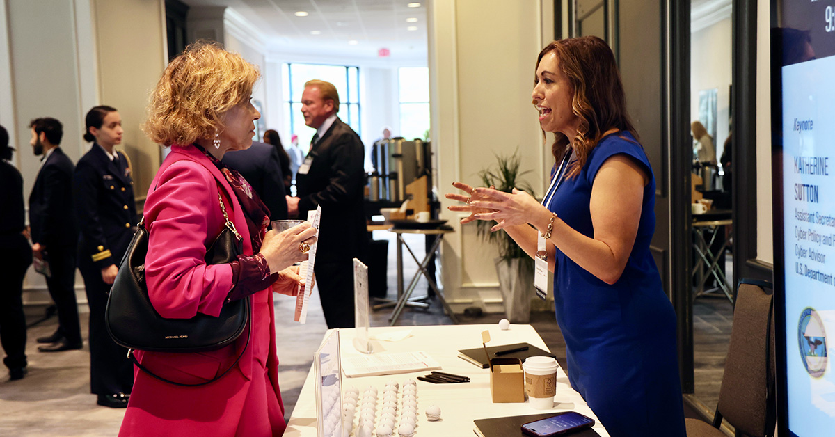 Networking at GovCon event. An event guest learns more about North Star Labs, a platinum sponsor of the 2026 Cyber Summit from Potomac Officers Club.