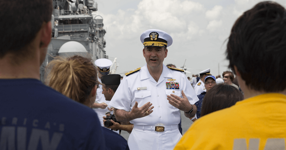 Then-Rear Adm. Brad Skillman talks with newly enlisted sailors after giving them the oath of enlistment on the flight deck of the Wasp-class amphibious assault ship USS Kearsarge (LHD 3) during Navy Week New Orleans.